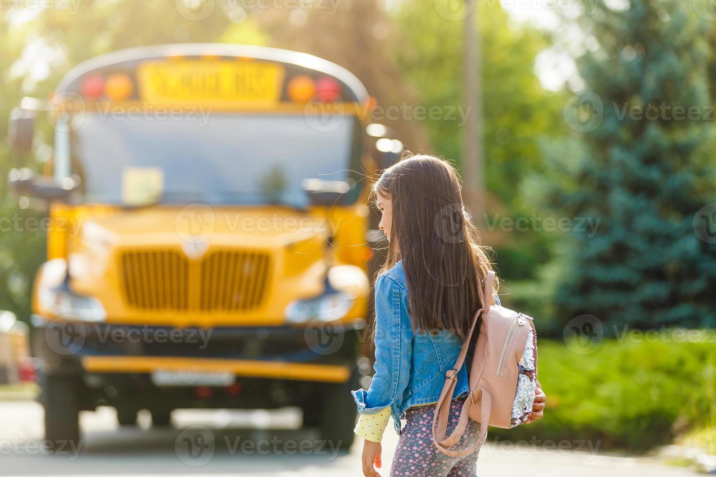 colegiala está esperando un autobús escolar foto