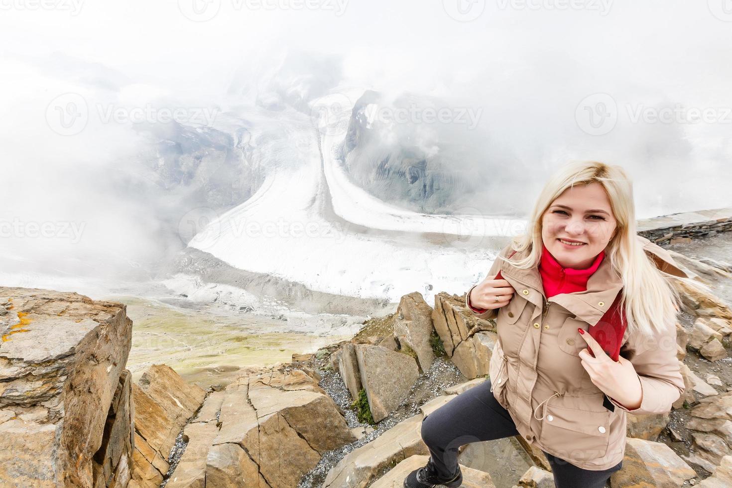 Rear view of a woman with backpack looking at the view Female hiker relaxing on mountain top. photo