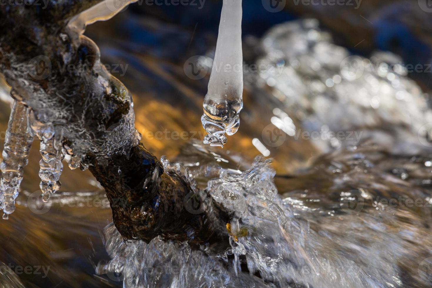 carámbanos en un pequeño río forestal foto