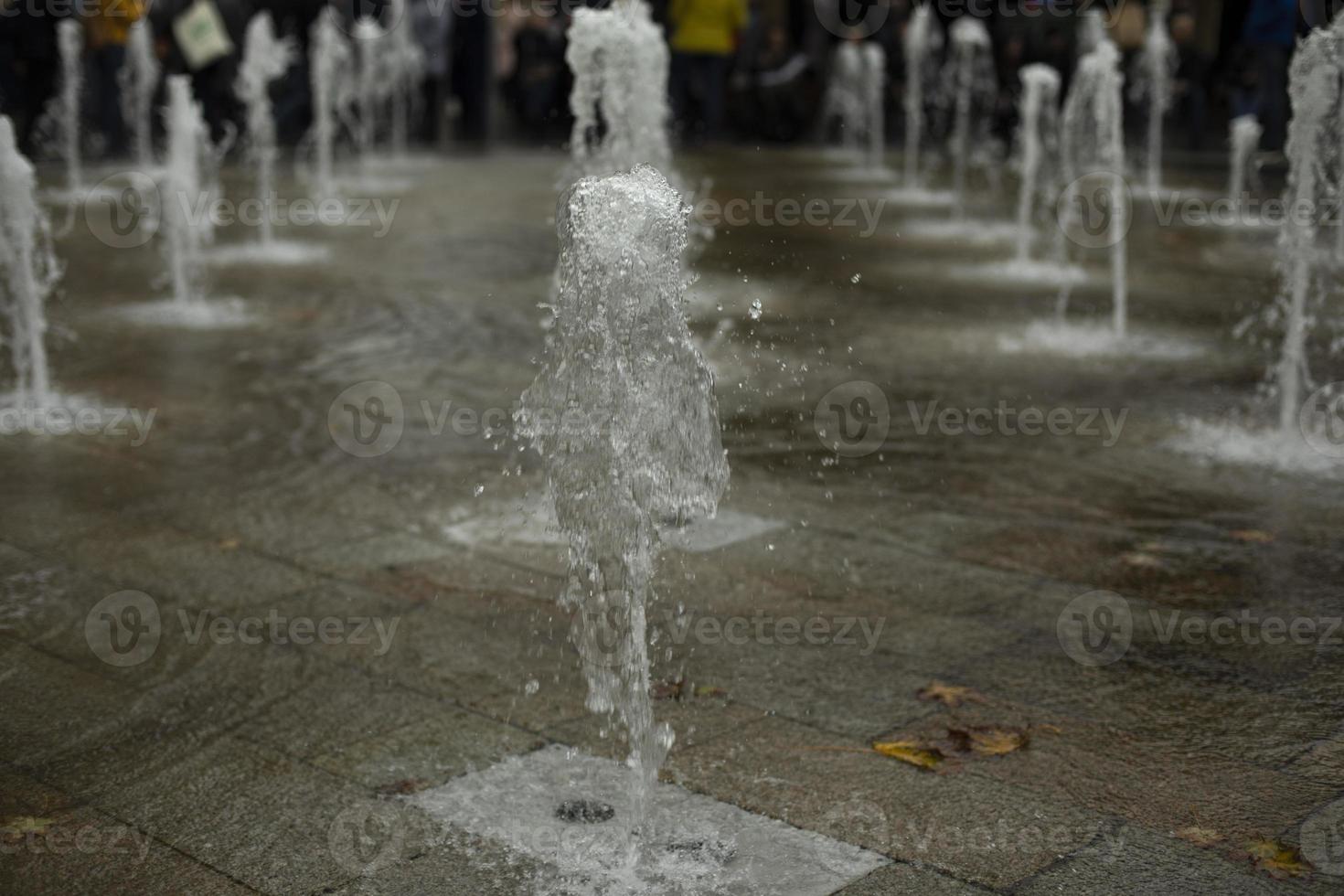 Fountain in city. Water jets in area. Flow of water. photo