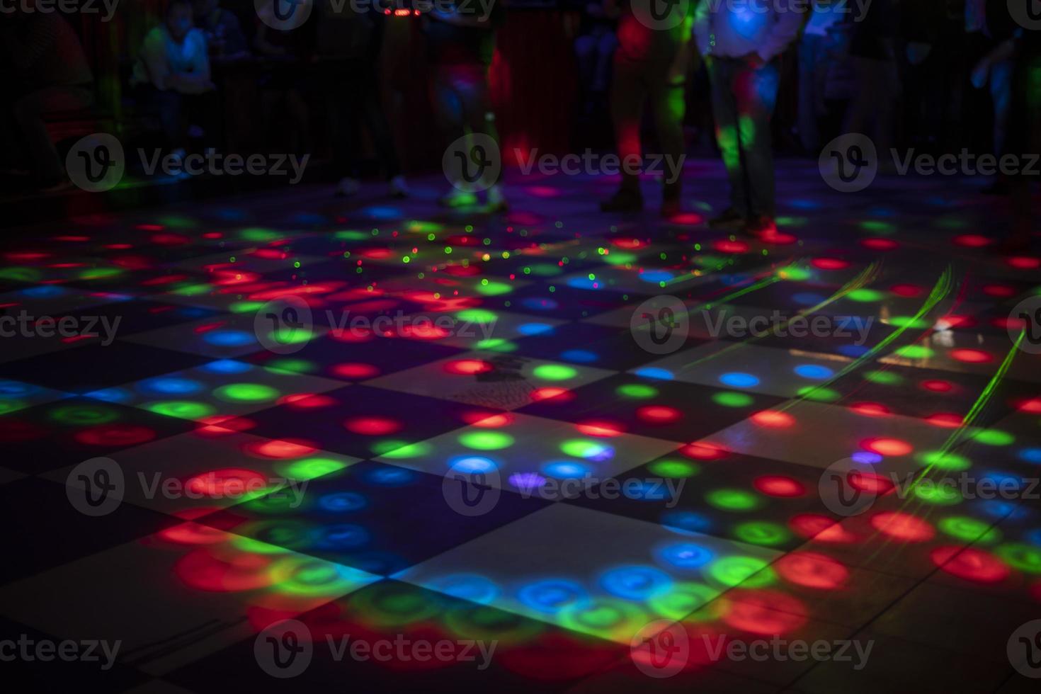 Disco on dance floor. Flower spots on floor. Color music indoors. photo