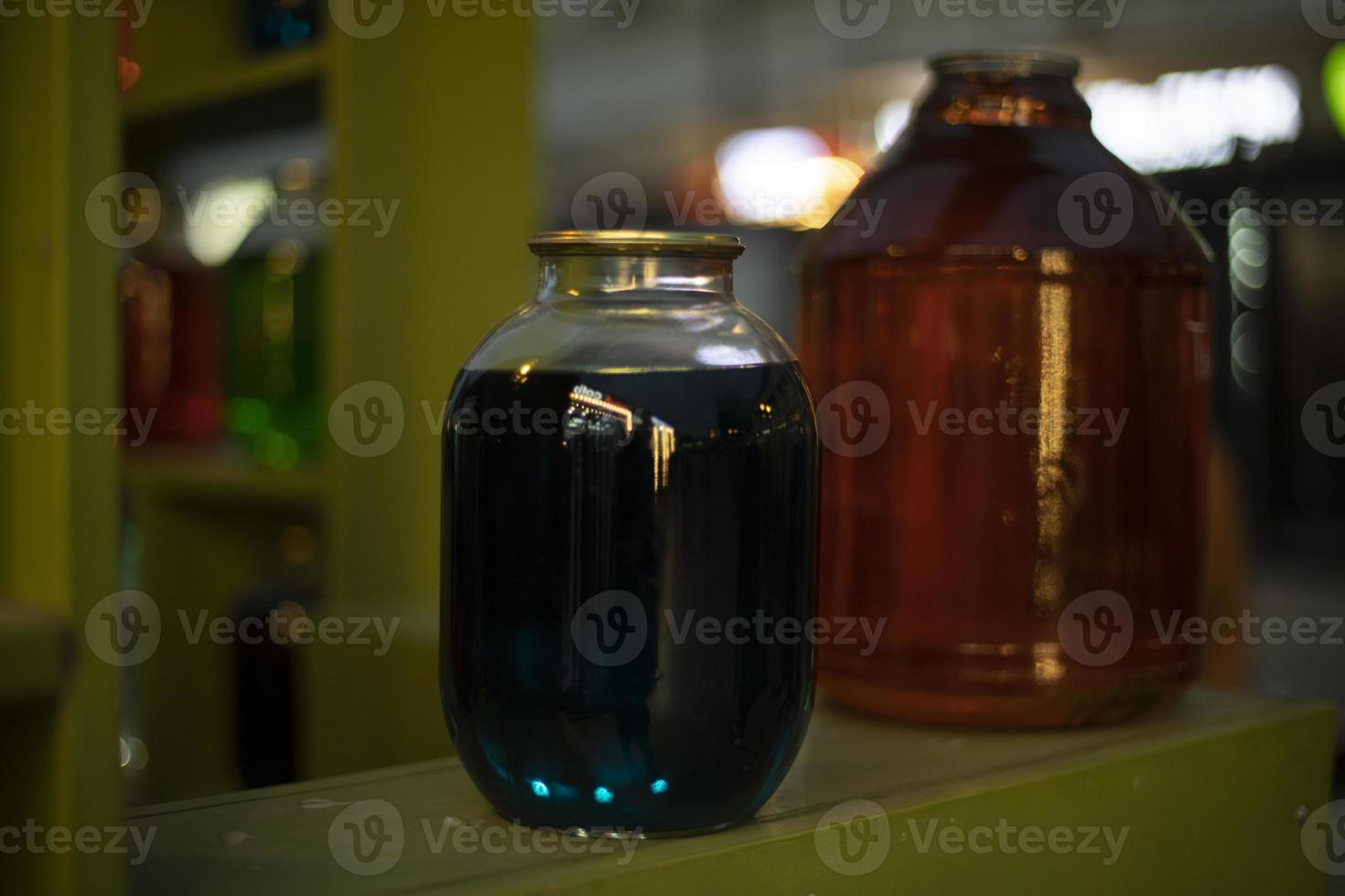 Cans on shelf with colored water. Interior details. Glass containers. photo