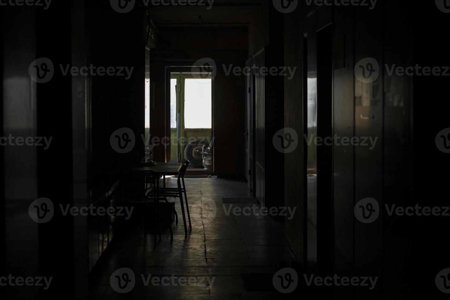 Interior light from window. Dark corridor and light at end. Reflection on floor. photo