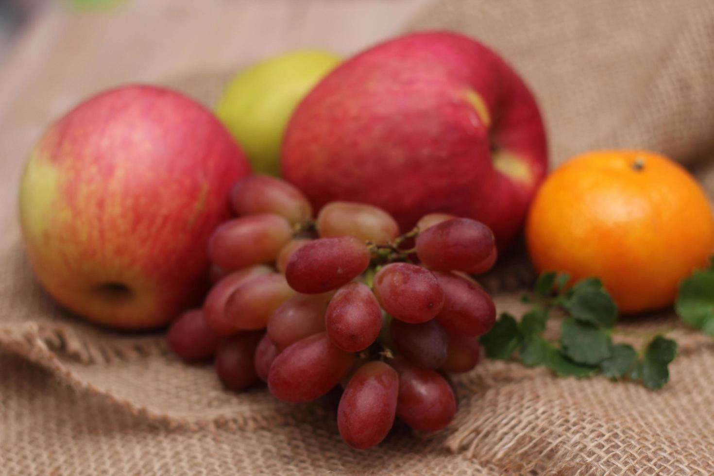 Fruits with vitamin C that are beneficial to the body. Place on sackcloth - orange, grape, apple, guava photo