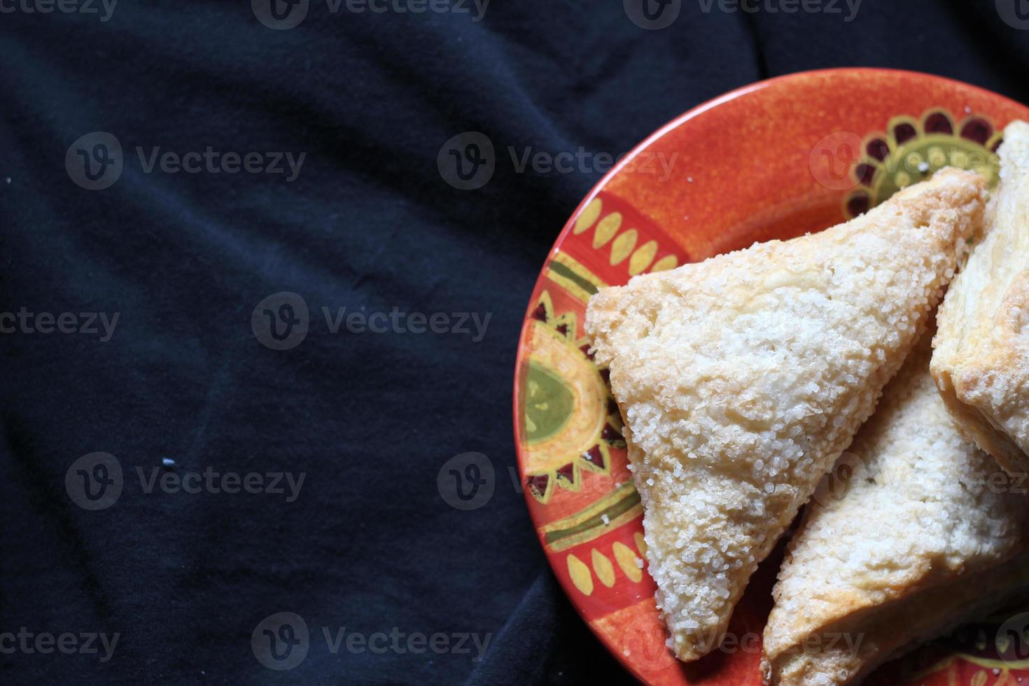 Turnovers Apple, Apple Pie, Served in an Orange Plate on a black cloth background, Turnovers Apple is a popular dish in America - Flat-Lay. photo