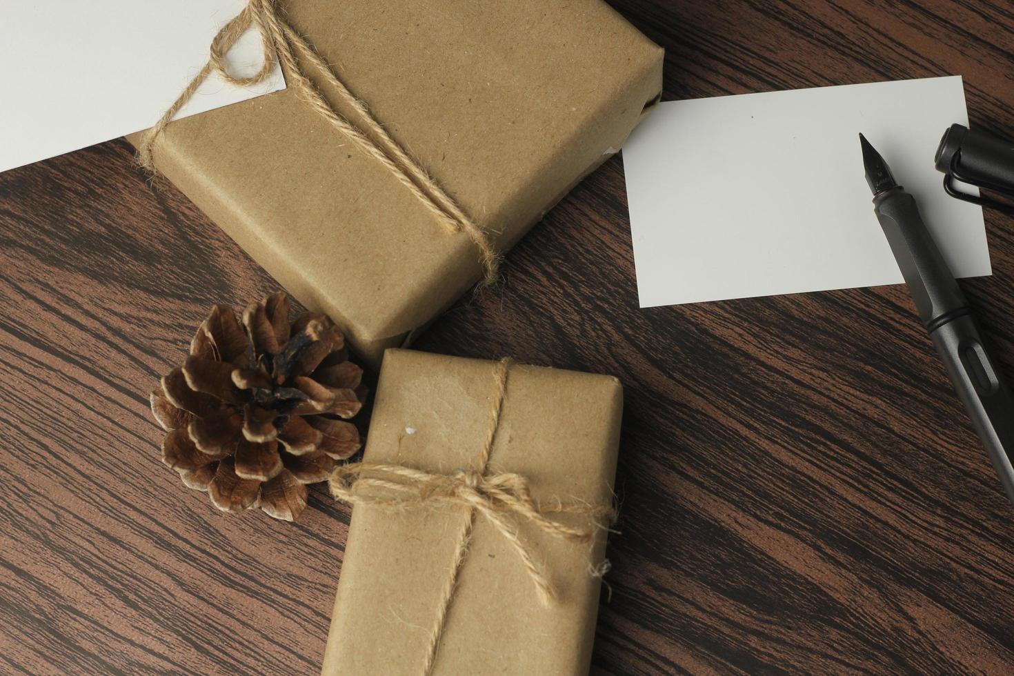 Se están preparando cajas de regalo de cumpleaños envueltas en papel reciclado en la mesa, vista superior, flatlay. foto