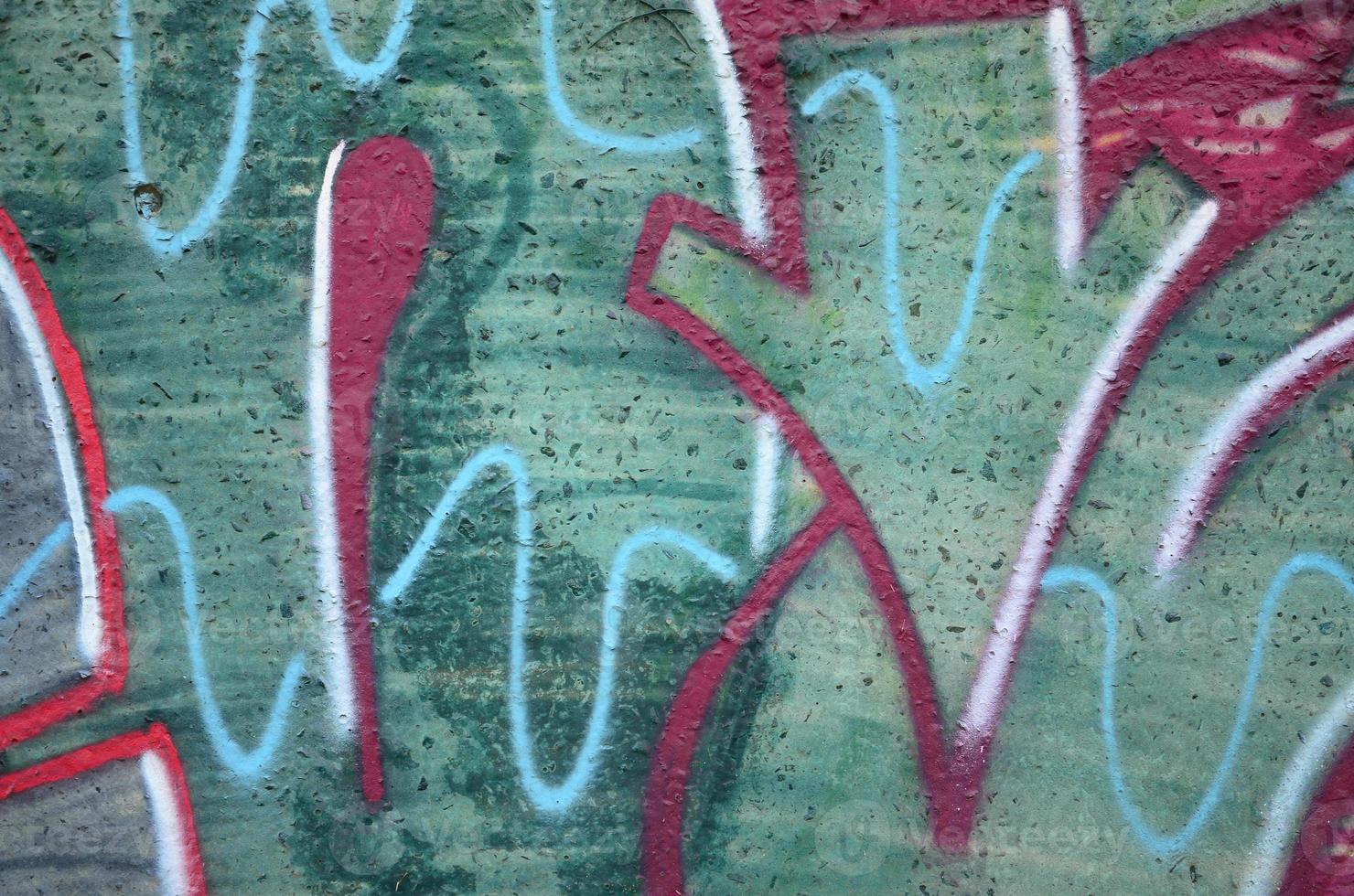 Texture of a fragment of the wall with graffiti painting, which is depicted on it. An image of a piece of graffiti drawing as a photo on street art and graffiti culture topics