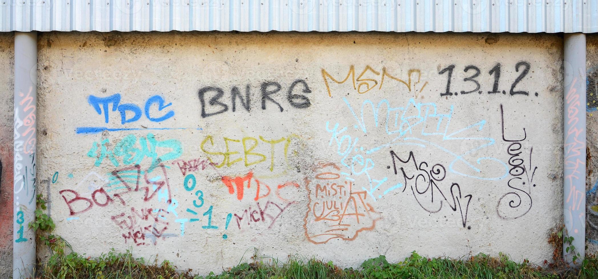 Texture of a fragment of the wall with graffiti painting, which is depicted on it. An image of a piece of graffiti drawing as a photo on street art and graffiti culture topics