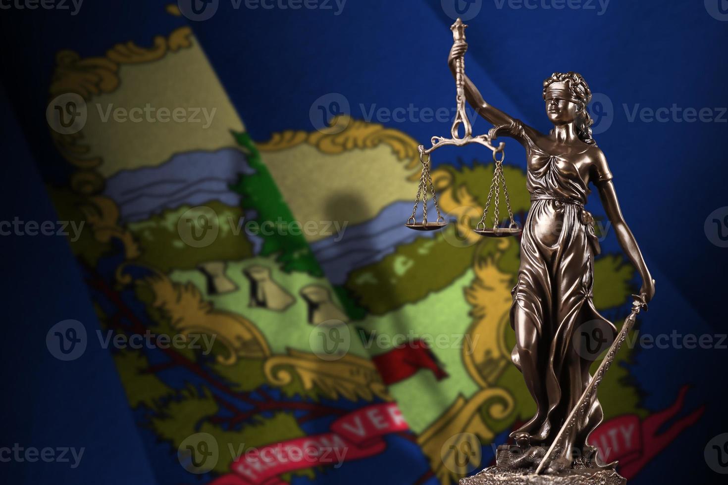 Vermont US state flag with statue of lady justice and judicial scales in dark room. Concept of judgement and punishment photo