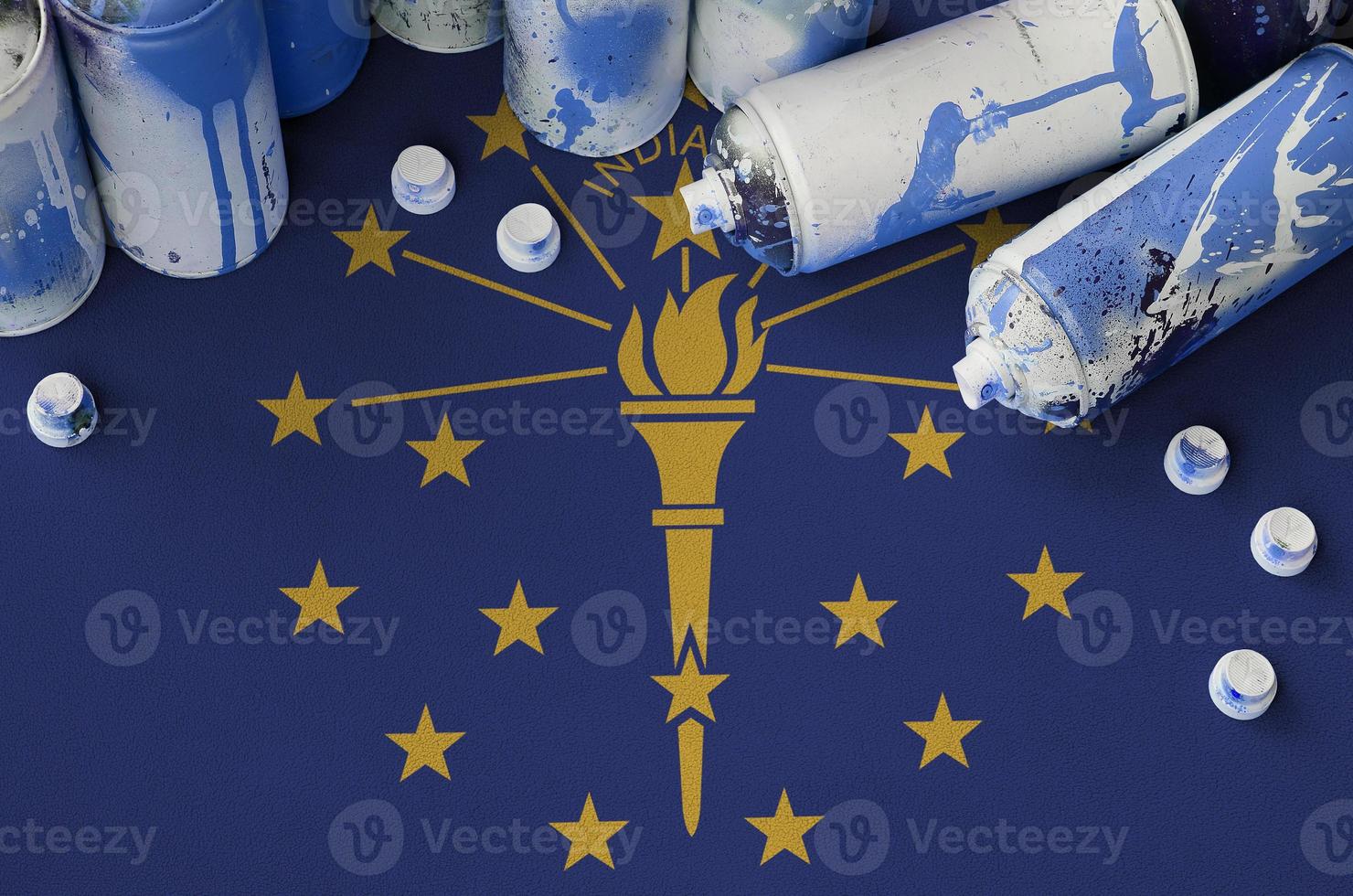 Indiana US state flag and few used aerosol spray cans for graffiti painting. Street art culture concept photo