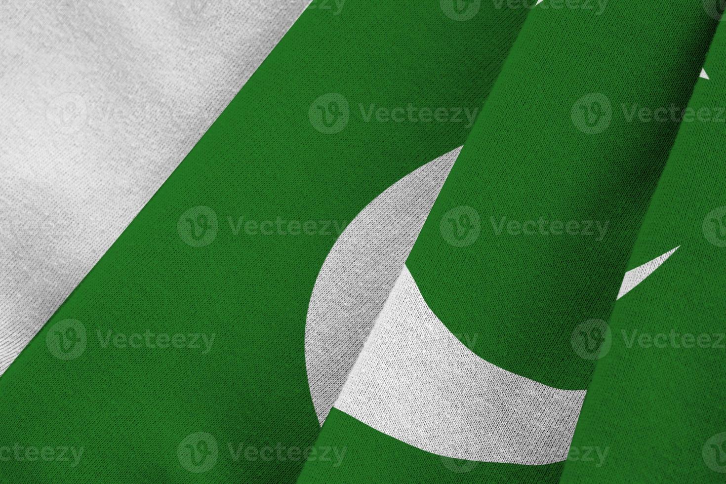 Pakistan flag with big folds waving close up under the studio light indoors. The official symbols and colors in banner photo