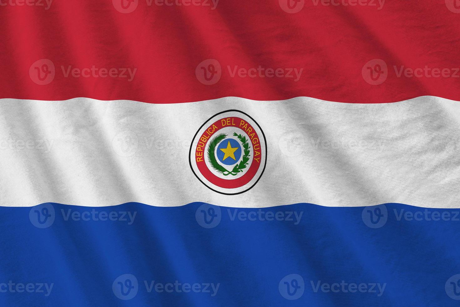 Paraguay flag with big folds waving close up under the studio light indoors. The official symbols and colors in banner photo