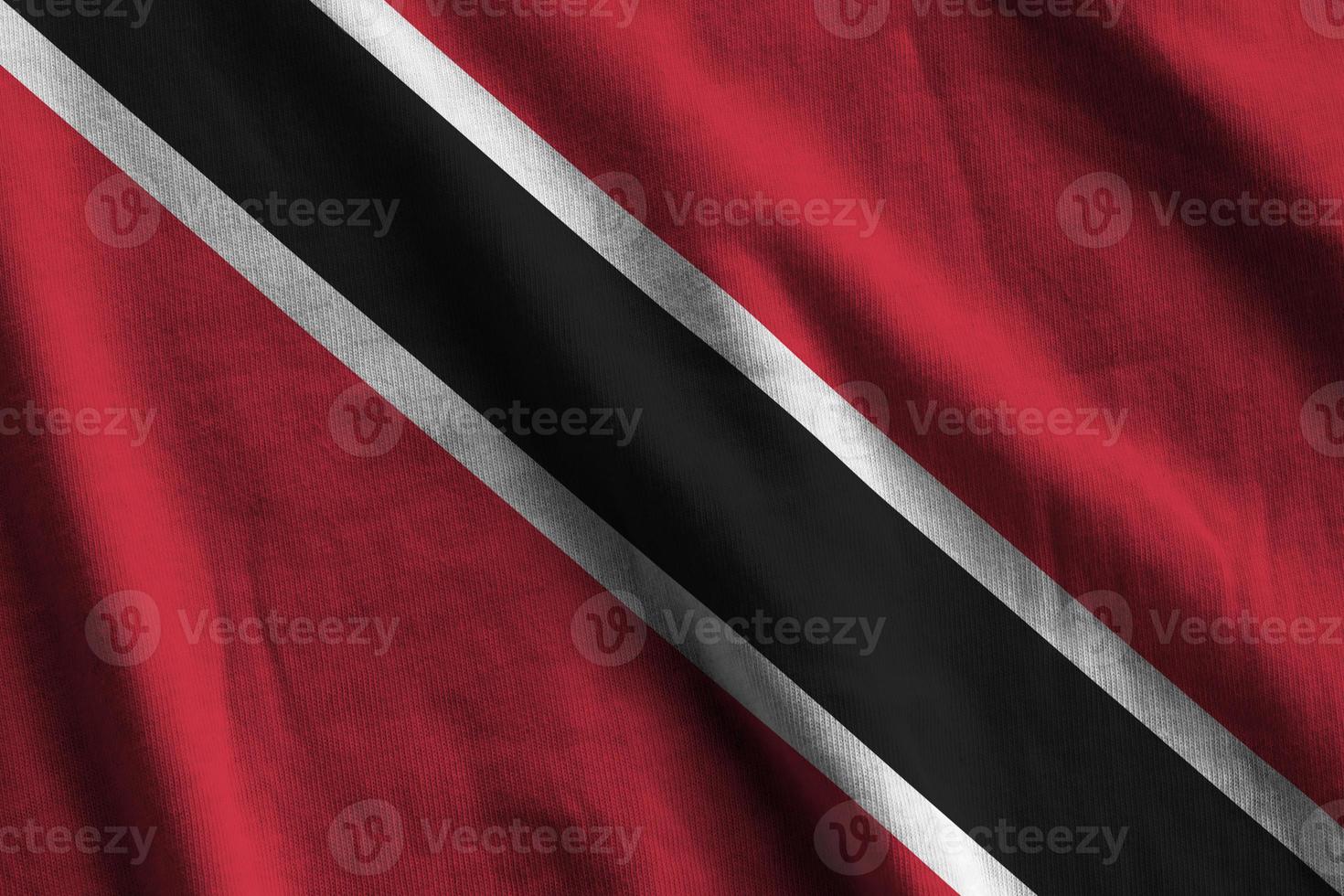 Trinidad and Tobago flag with big folds waving close up under the studio light indoors. The official symbols and colors in banner photo