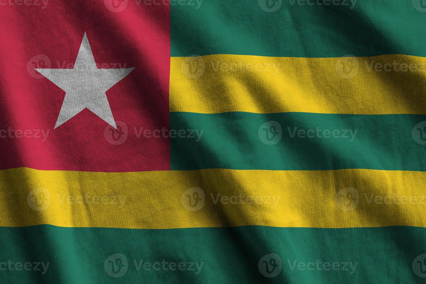Togo flag with big folds waving close up under the studio light indoors. The official symbols and colors in banner photo