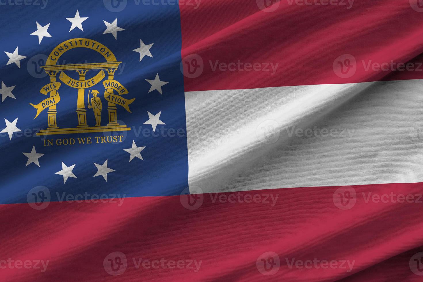 Georgia US state flag with big folds waving close up under the studio light indoors. The official symbols and colors in banner photo