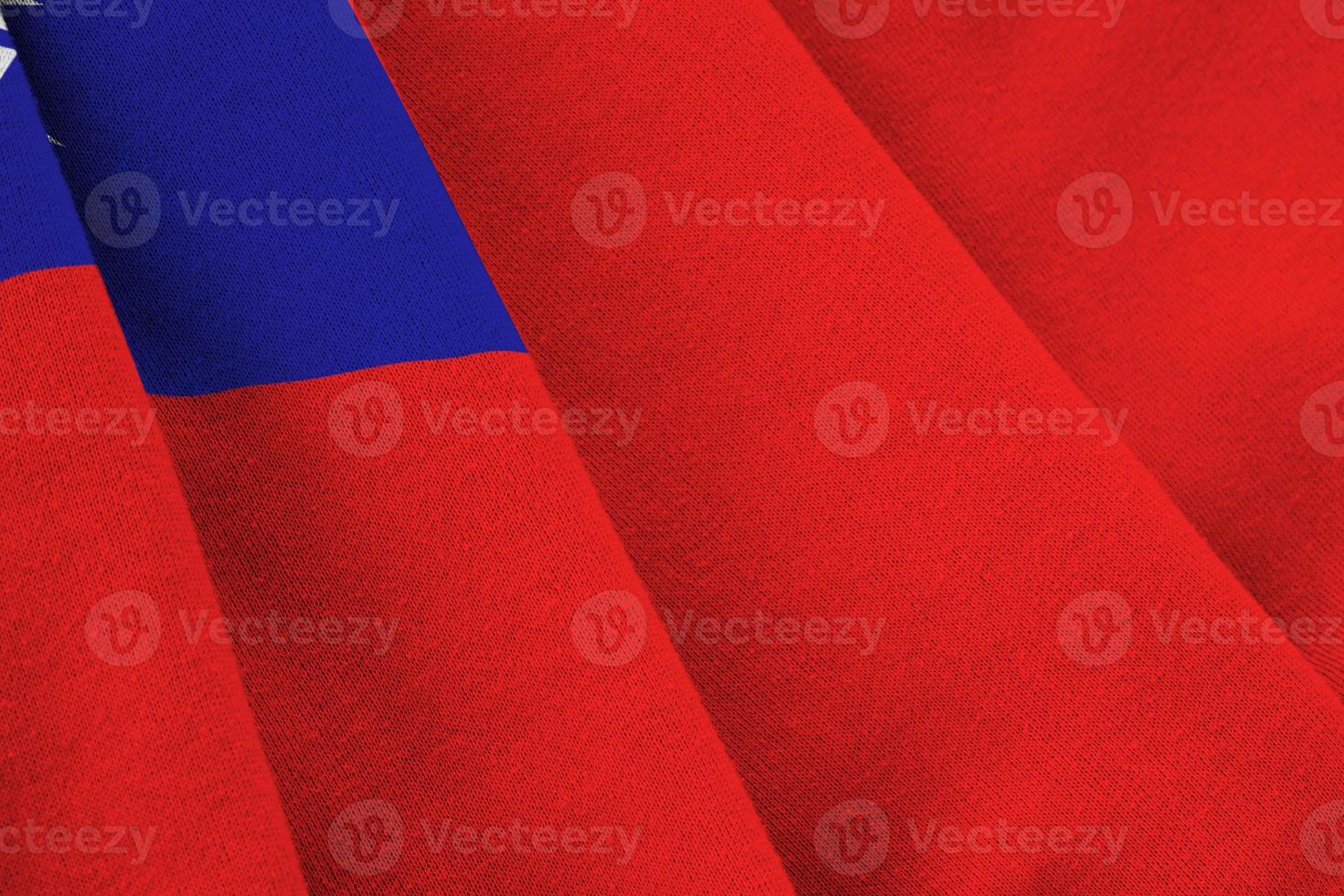 Taiwan flag with big folds waving close up under the studio light indoors. The official symbols and colors in banner photo