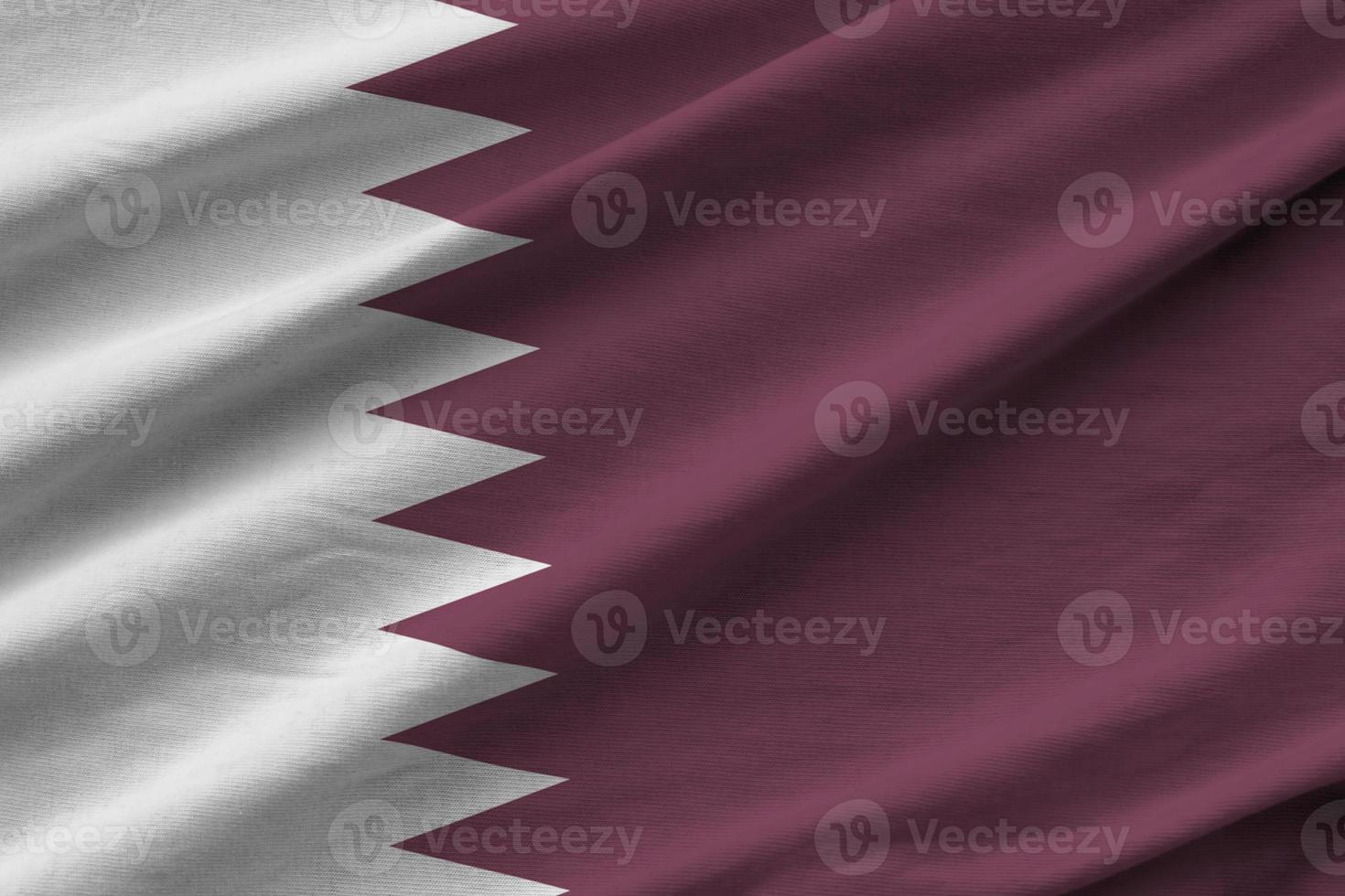 Qatar flag with big folds waving close up under the studio light indoors. The official symbols and colors in banner photo