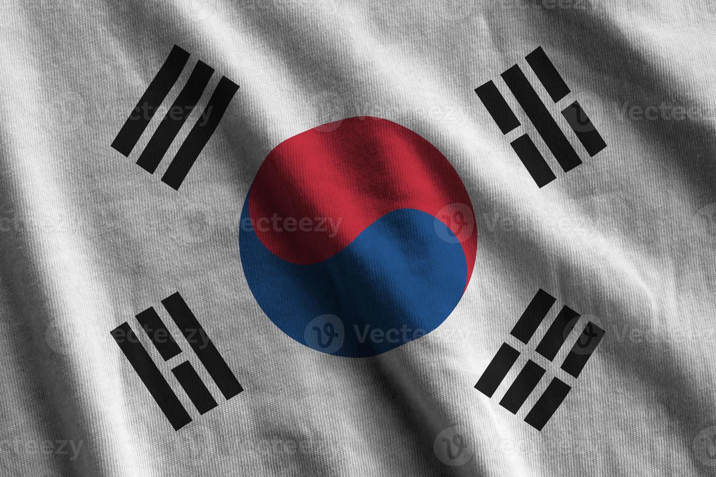 bandera de corea del sur con grandes pliegues ondeando de cerca bajo la luz del estudio en el interior. los símbolos y colores oficiales en banner foto