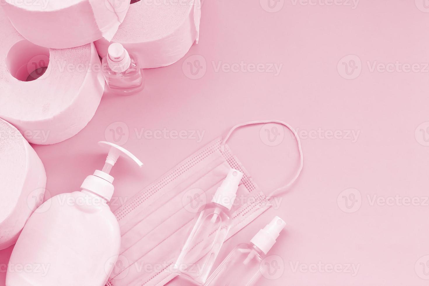 Set of important items for Covid-19 quarantine times. Toilet paper with surgical face mask and hand sanitizer with liquid soap bottle Image toned in Viva Magenta, color of the 2023 year photo