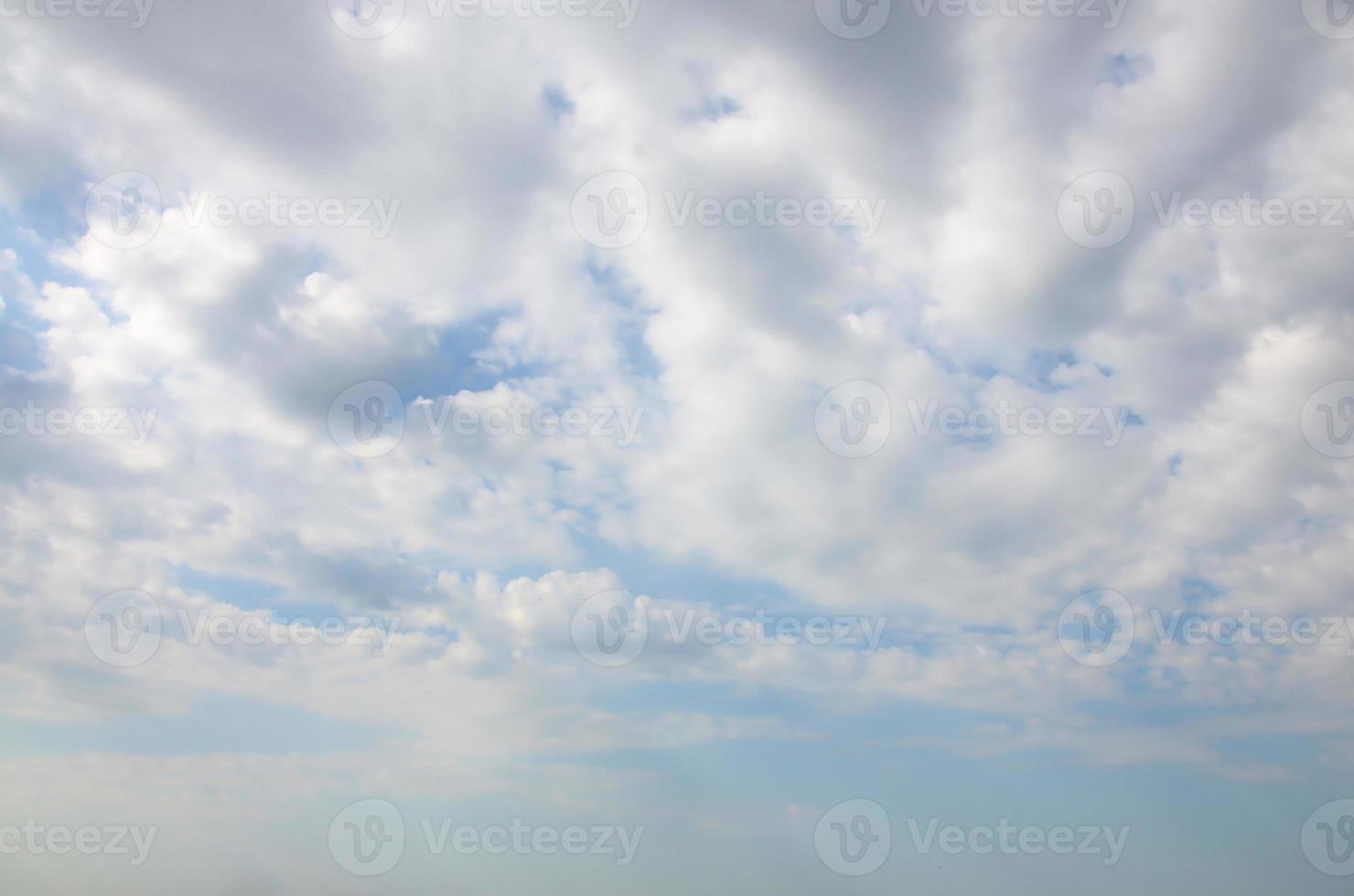 Blue sky background with white fluffy clouds in daytime outdoors photo