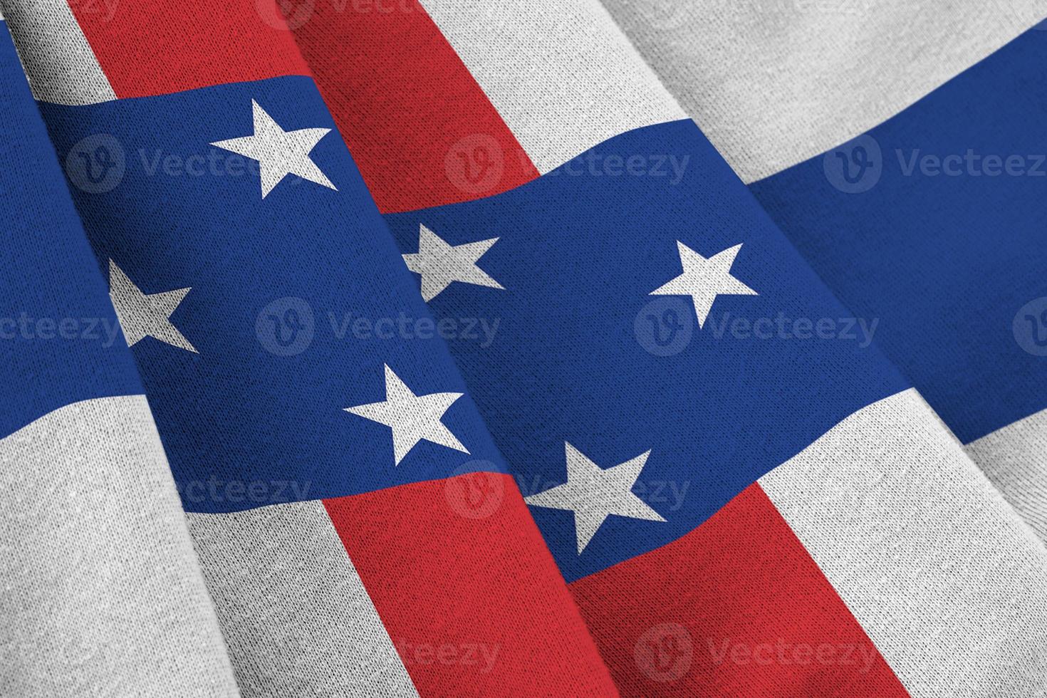 Netherlands Antilles flag with big folds waving close up under the studio light indoors. The official symbols and colors in banner photo