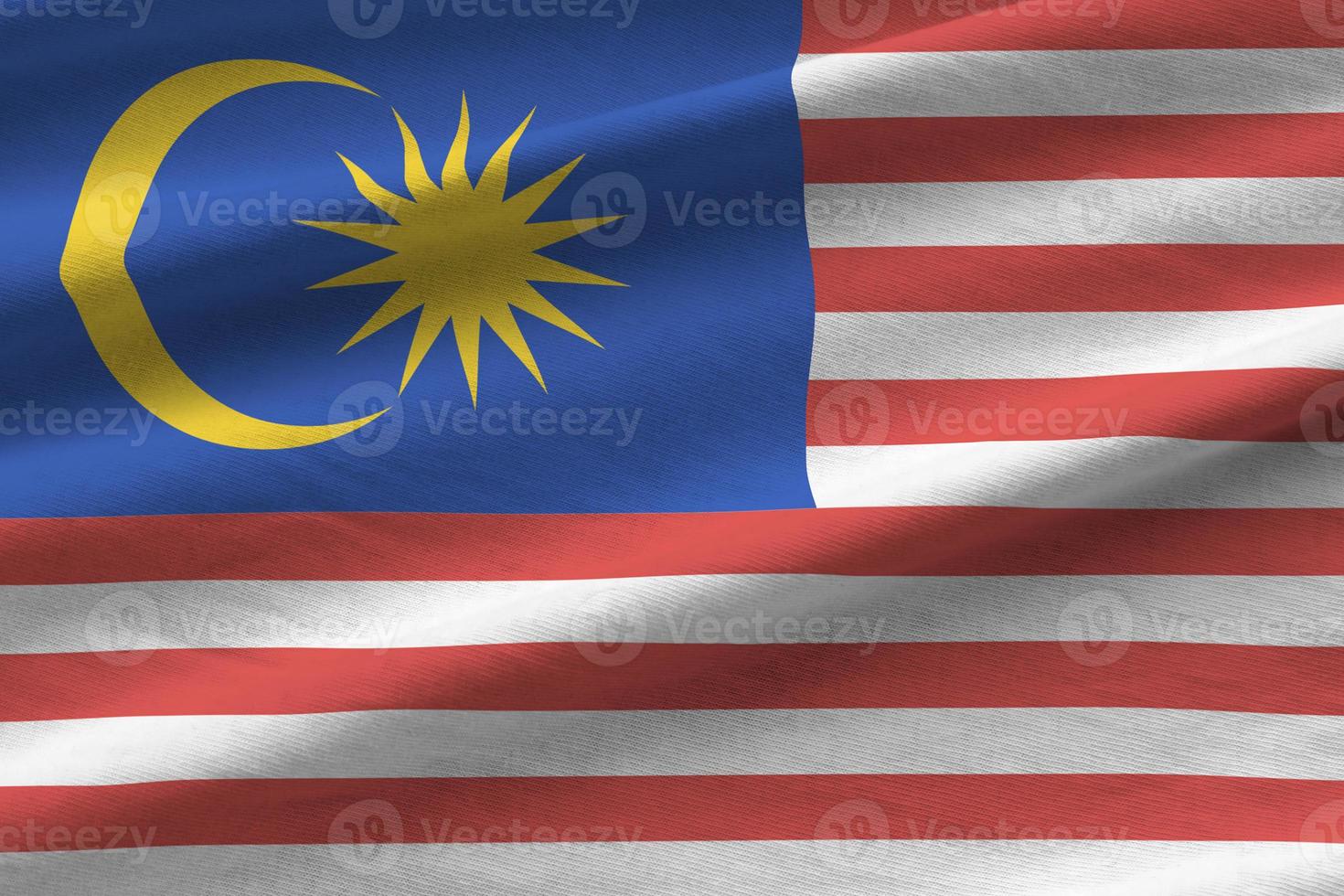 Malaysia flag with big folds waving close up under the studio light indoors. The official symbols and colors in banner photo