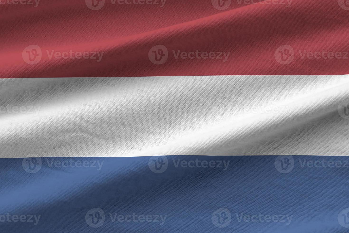 Netherlands flag with big folds waving close up under the studio light indoors. The official symbols and colors in banner photo