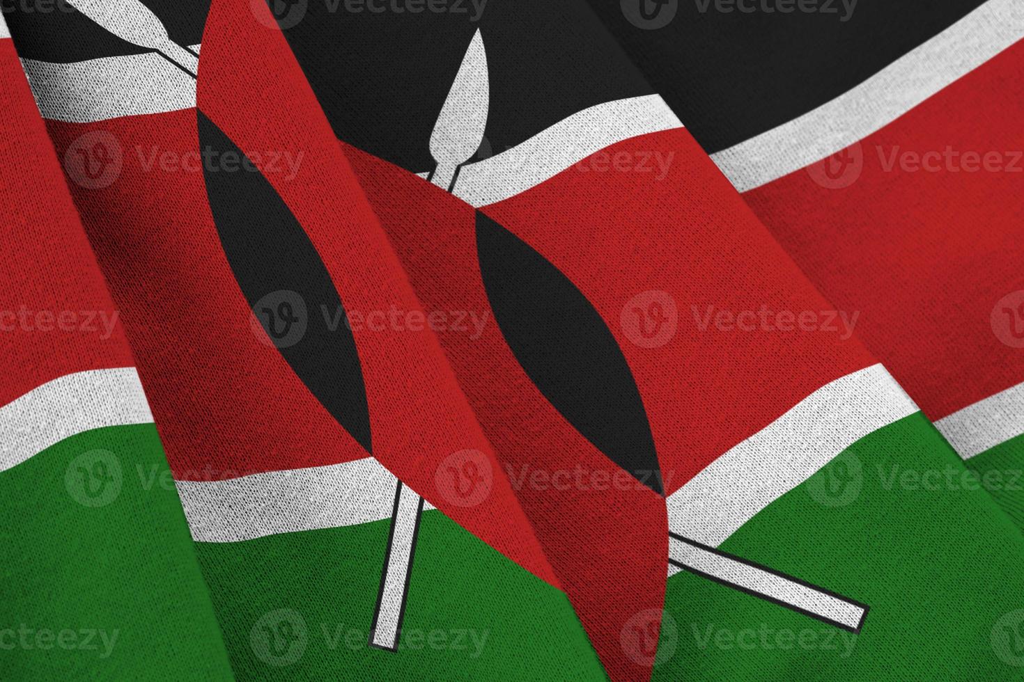 Kenya flag with big folds waving close up under the studio light indoors. The official symbols and colors in banner photo