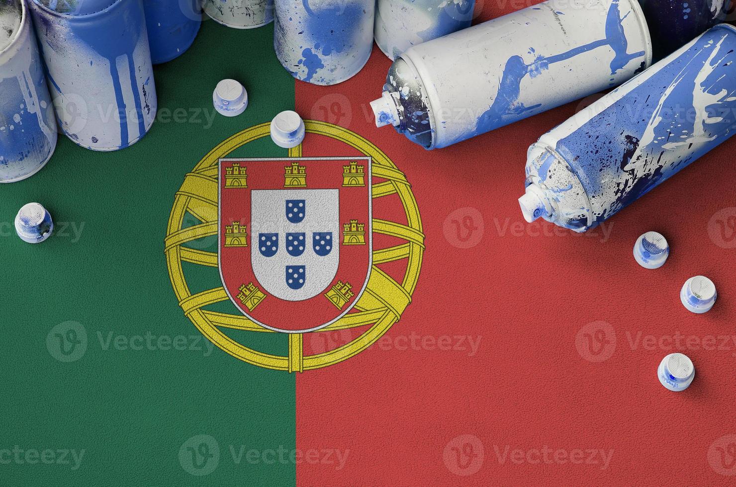 bandera de portugal y pocas latas de aerosol usadas para pintar graffiti. concepto de cultura de arte callejero foto