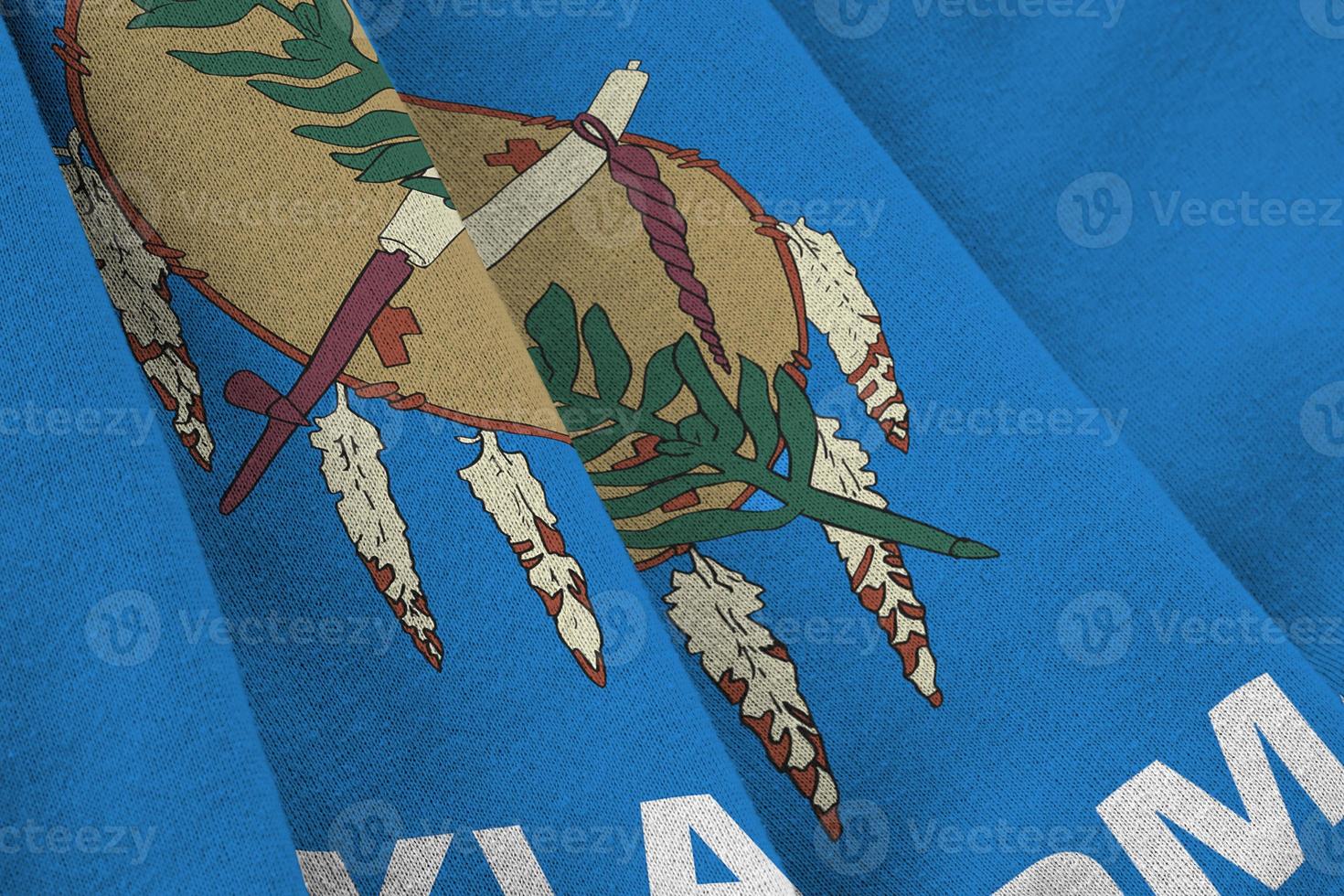 Oklahoma US state flag with big folds waving close up under the studio light indoors. The official symbols and colors in banner photo