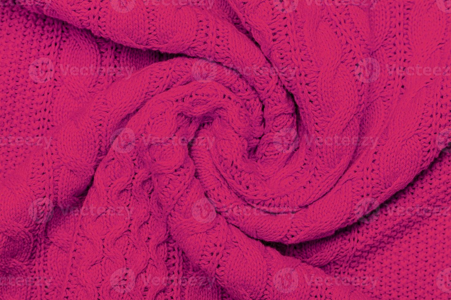 The texture of warm knitted sweater. Beautiful handmade knitted repeating pattern. Demonstrating Pantone color of the year 2023 viva magenta photo