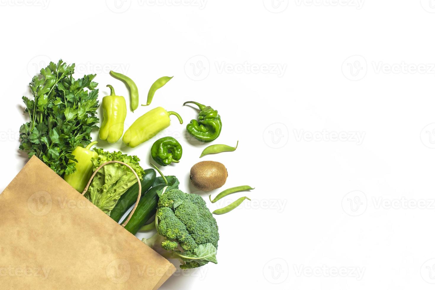 bolsa de papel ecológica con vegetales verdes orgánicos crudos aislados en fondo blanco plano, vista superior cero desperdicio, concepto libre de plástico dieta saludable y desintoxicación, concepto de agricultura foto