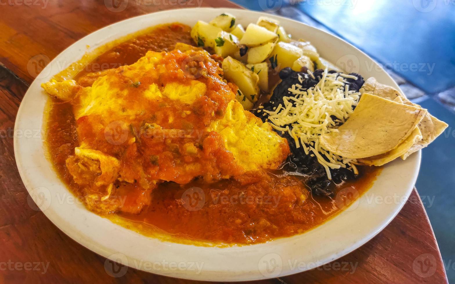 Mexican omelet eggs black beans potatoes nachos on white plate. photo