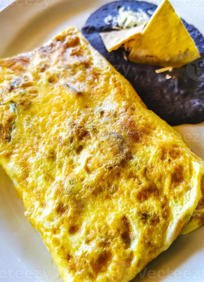 Mexican omelet eggs black beans potatoes nachos on white plate. photo