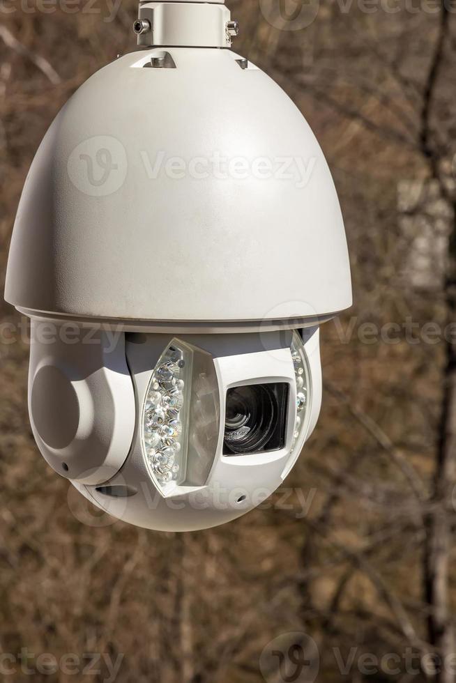 Close up a security CCTV camera outside in the brown background photo