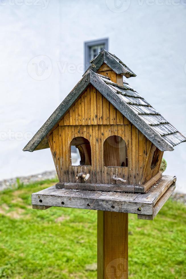 pequeña casa de árbol de madera en el parque. pajarera vacía hecha a mano de madera al aire libre en el jardín foto
