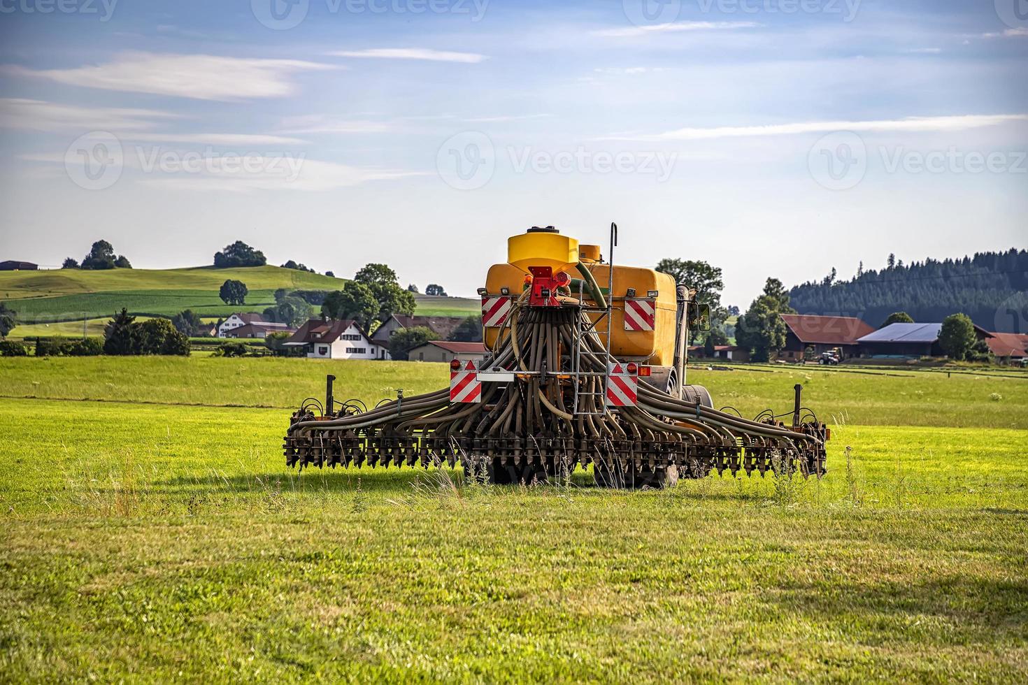 Application of manure on arable farmland with the heavy tractor works at the field in Germany photo