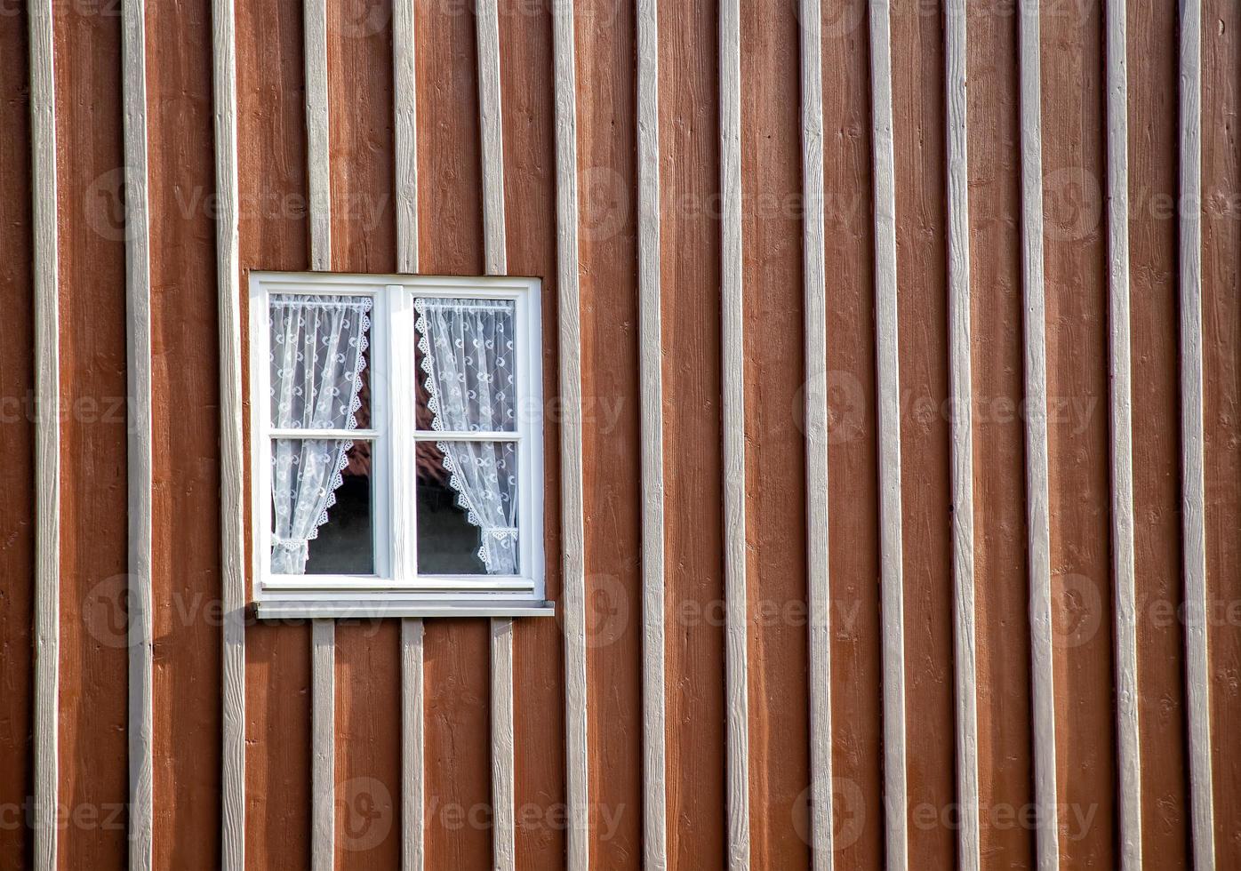 beauty wooden window with curtains in a house facade wall. photo