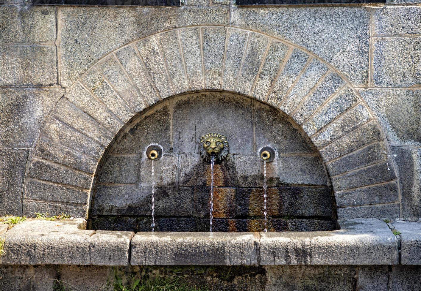 Drinking fountain. An urban drinking fountain. Public mixer for drinking water. Stone fountain water. photo