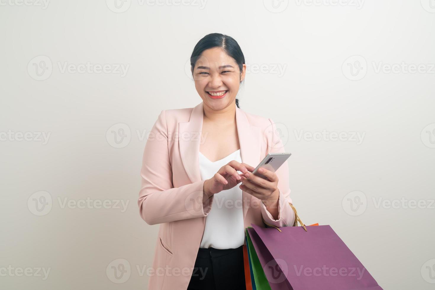Asian woman using smartphone with shopping bag on hand photo