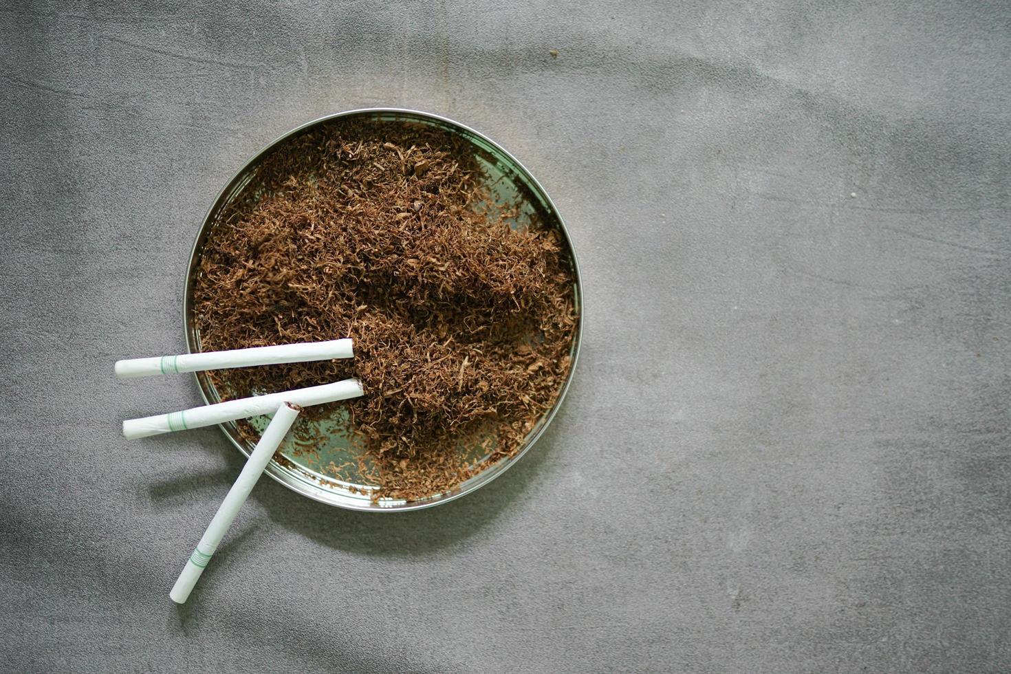 tobacco with cigarette on concrete background photo