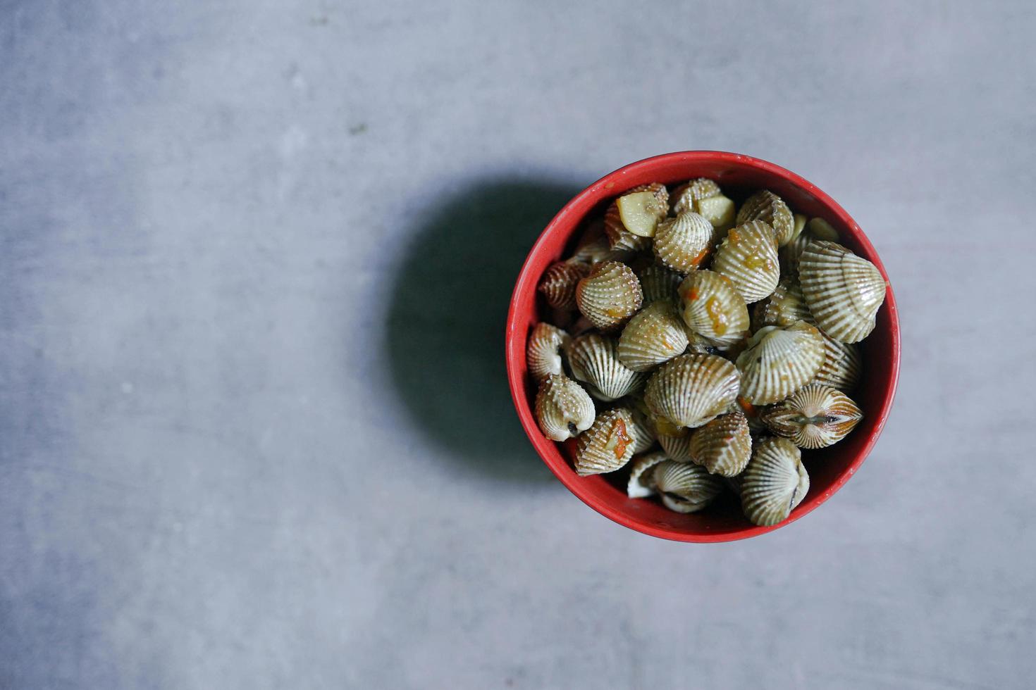 clams in hot sauce in a bowl on a concrete background photo