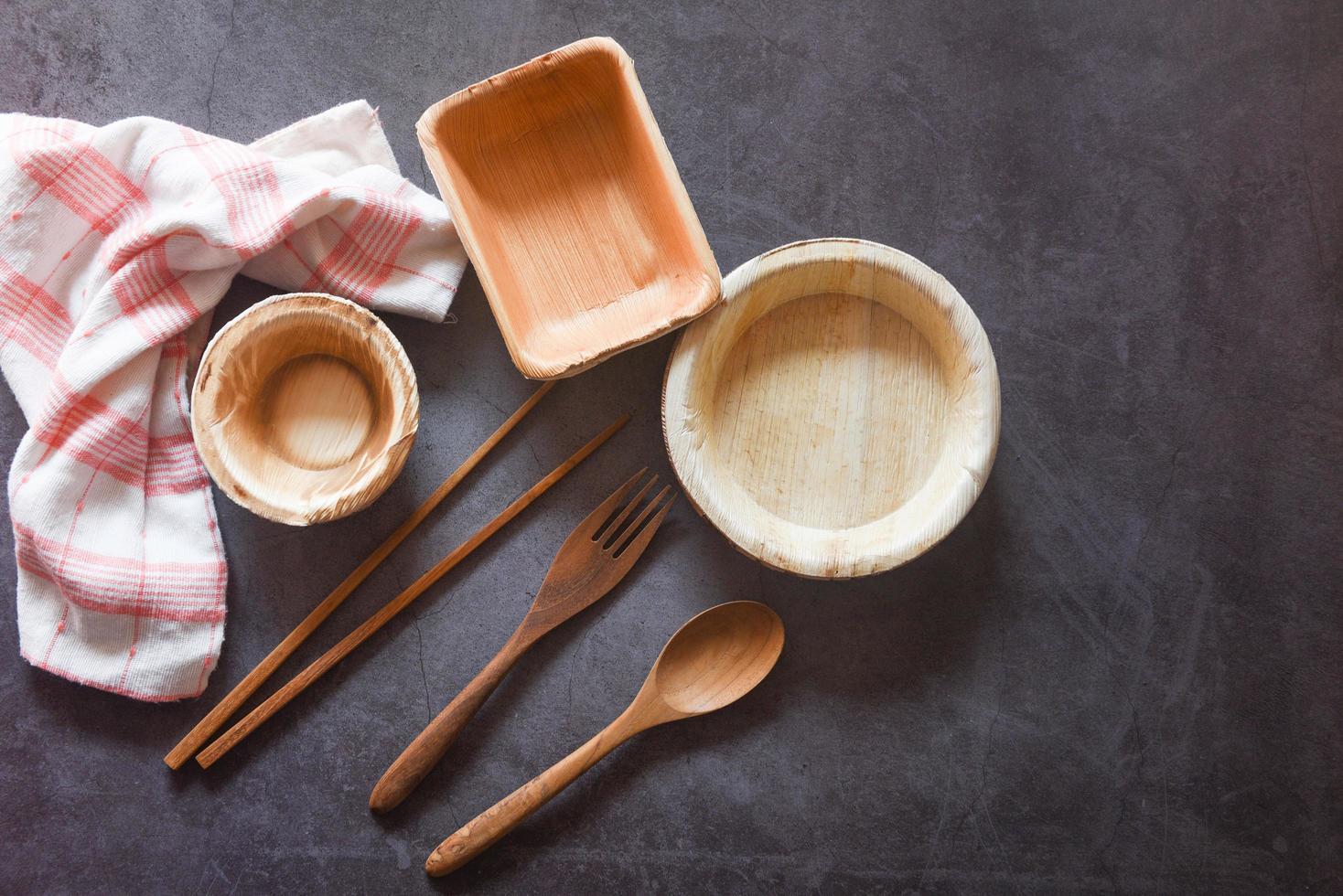 Eco friendly disposable tableware from palm leaf or betel nut , zero waste environment concept Natural eco-friendly food packaging disposable utensils with dish plate bowl cup and wooden fork spoon photo