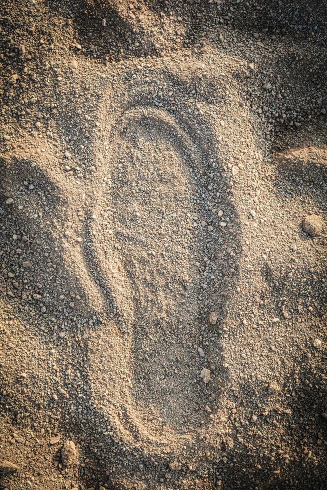 Shoe track on sand Imprint footprint on ground traces of feet texture background photo
