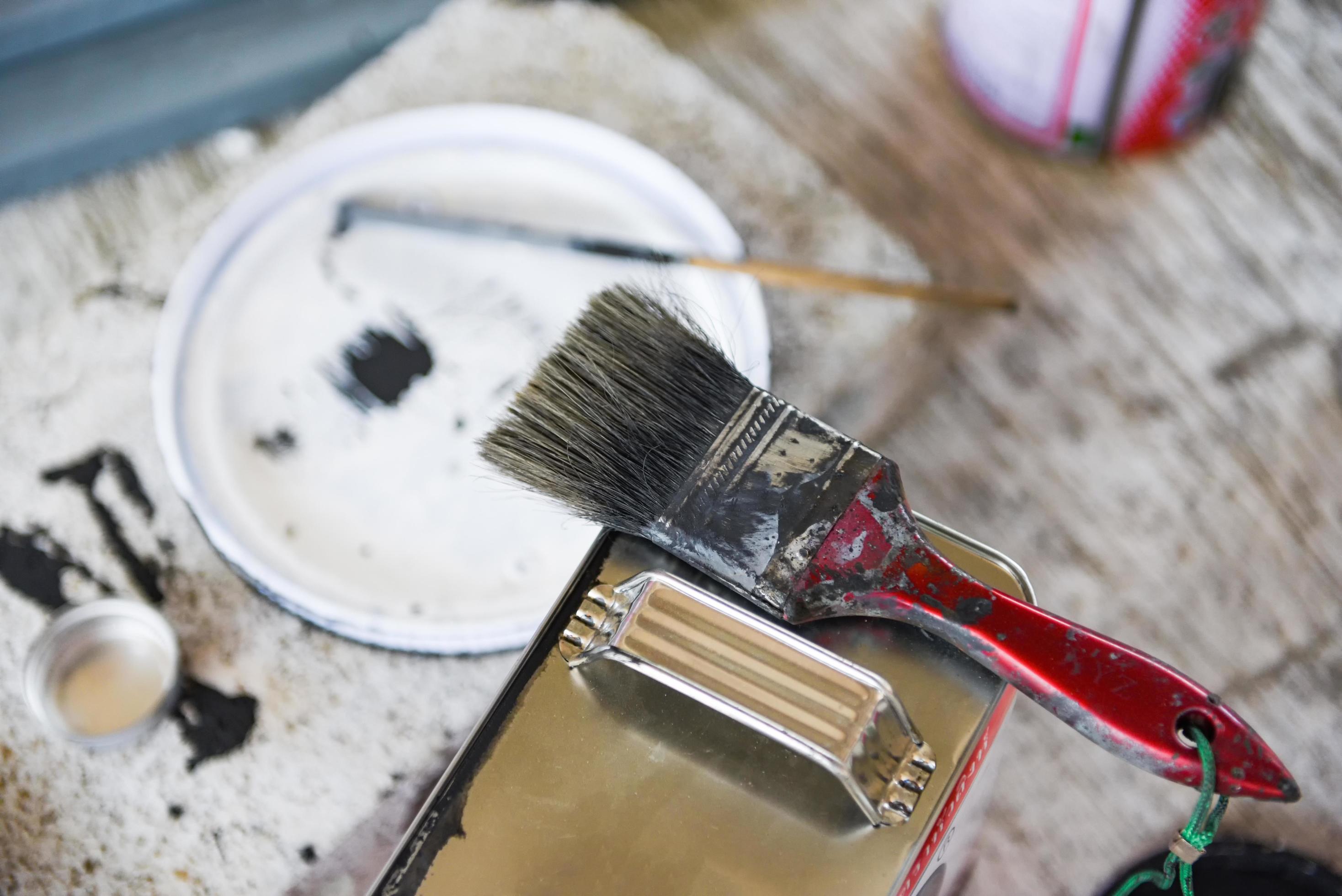 old paint brush on paint can Ready to be disposed dirty paint brushes