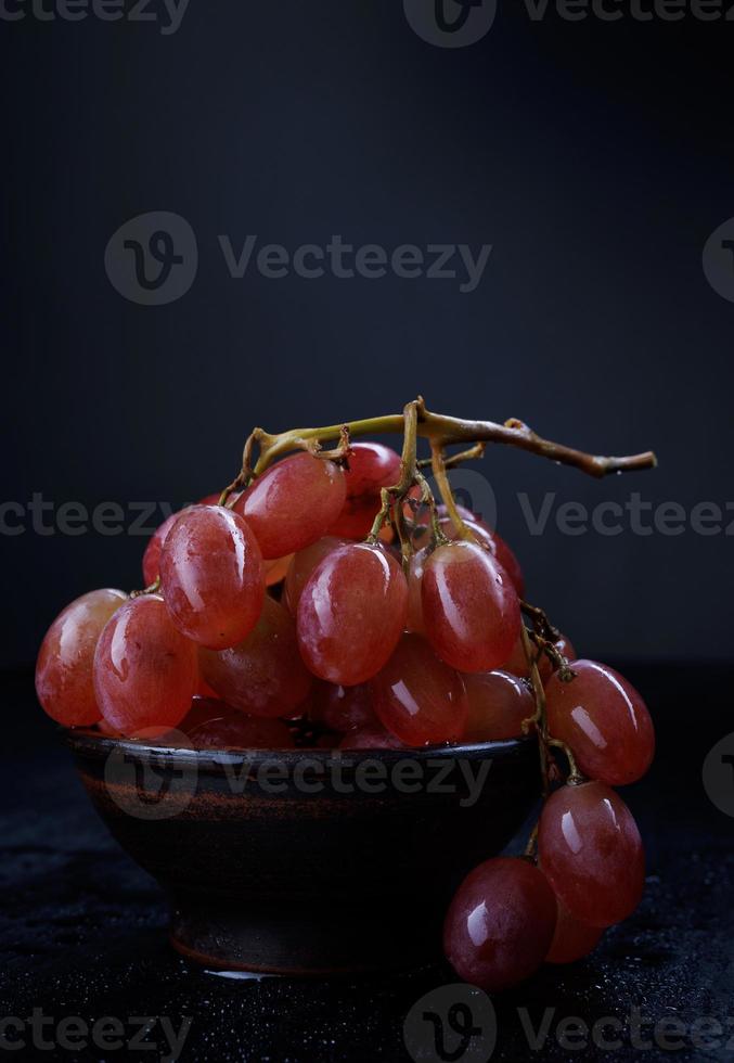 Red grapes in a ceramic plate. Bunch of ripe grapes. photo