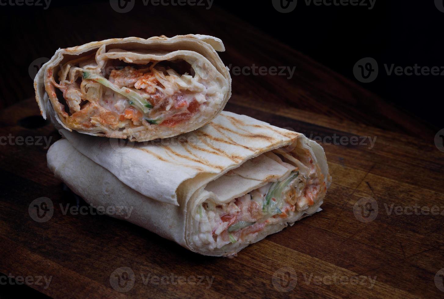 The cut shawarma lies on a wooden table. photo