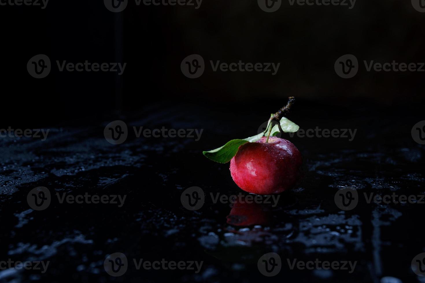 Red apple on a black background. Water drops . photo