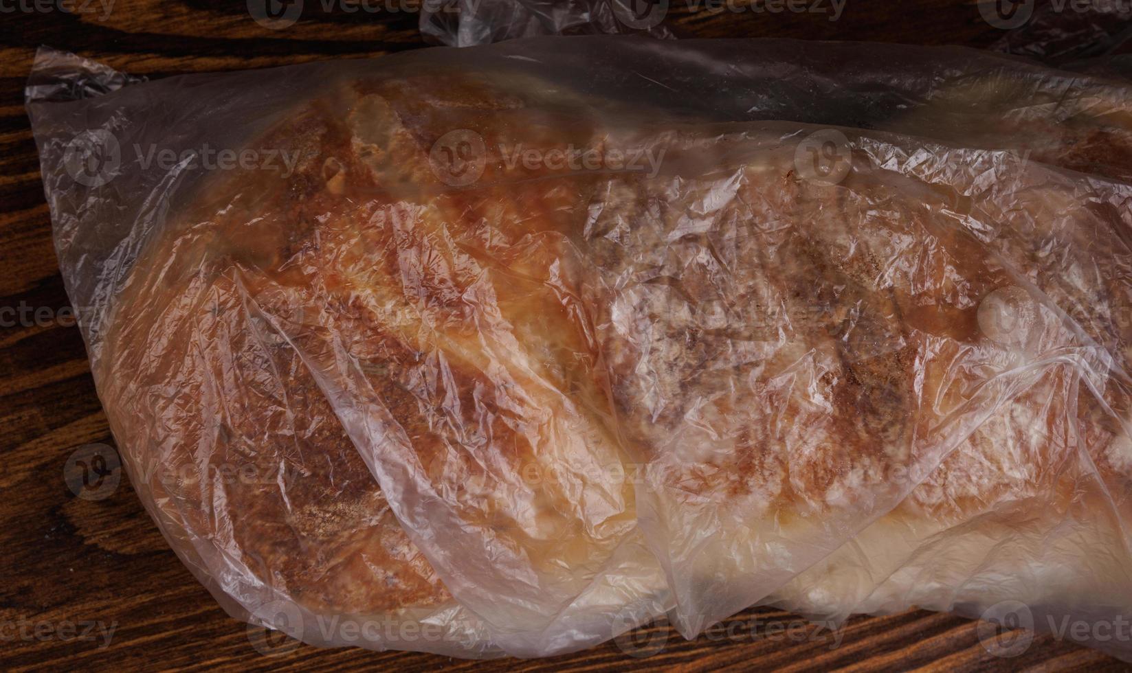 A loaf of bread wrapped in a plastic bag. photo