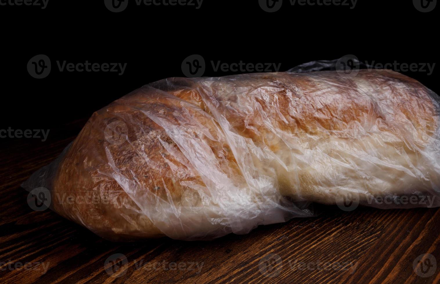 A loaf of bread wrapped in a plastic bag. photo